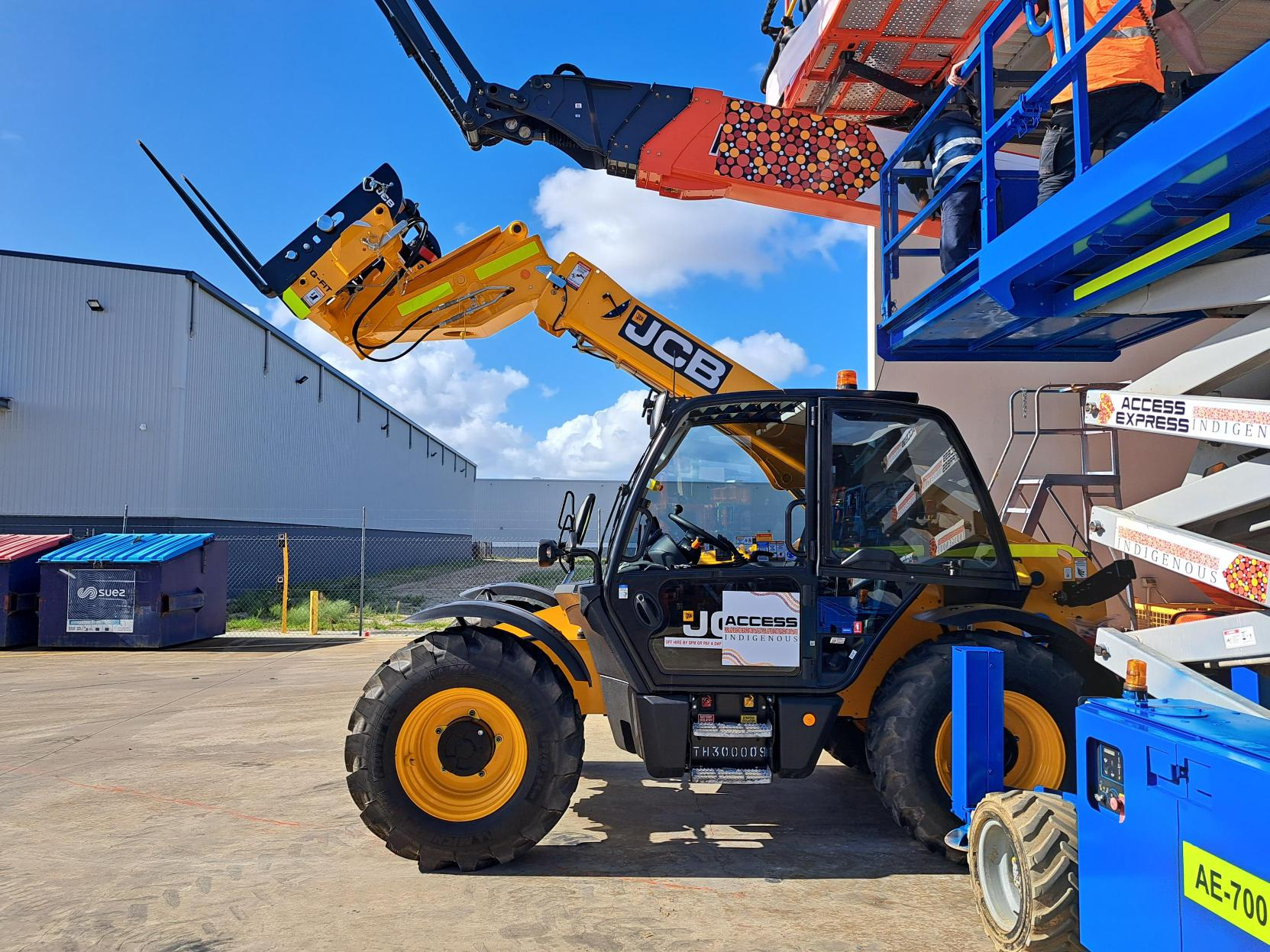 JCB telehandler lifting elevated work platform at Access Hire equipment yard